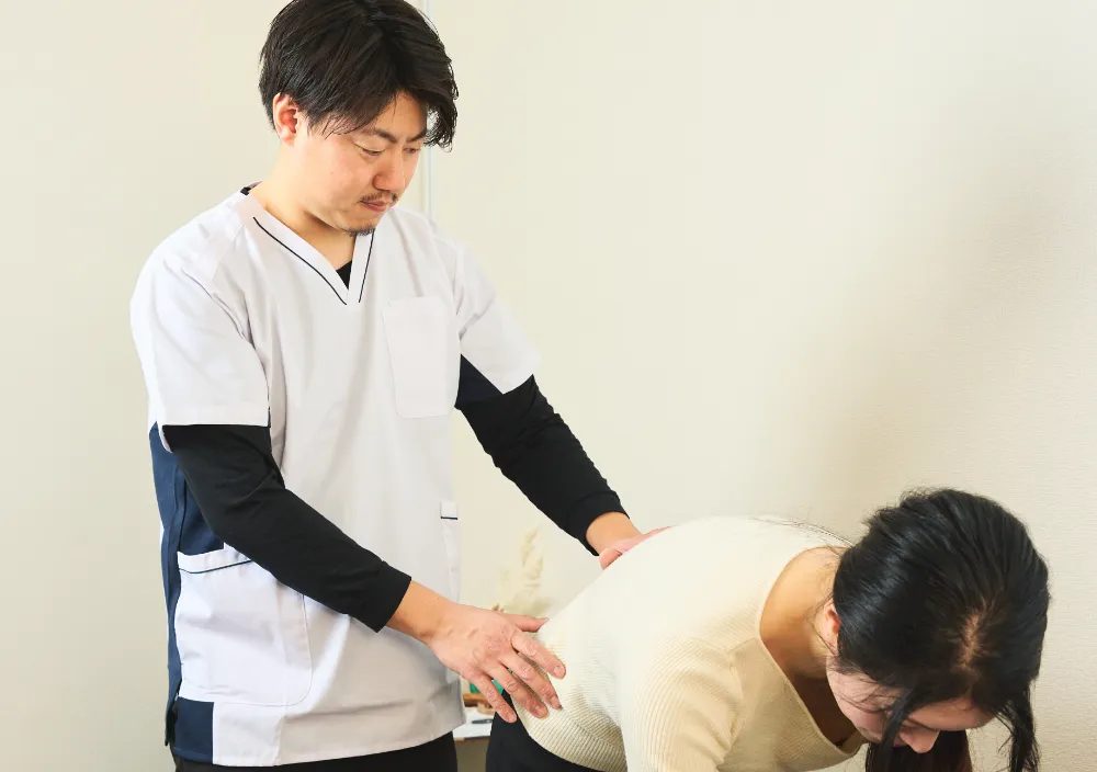 施術後の検査を行う整体師