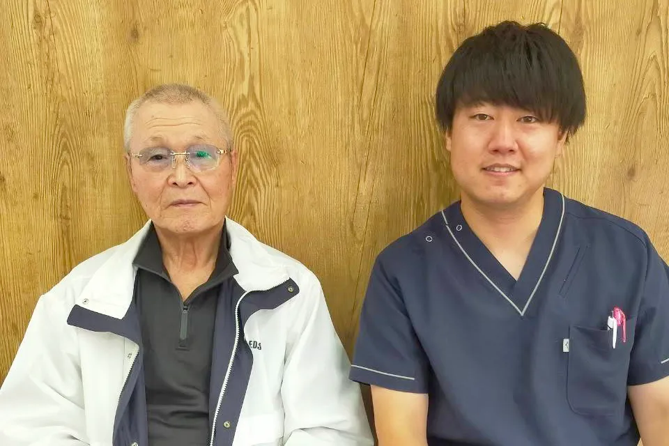 症状が改善した患者と並ぶ整体師
