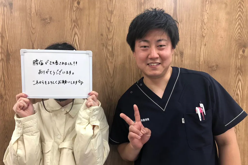 症状が改善した患者と並ぶ整体師