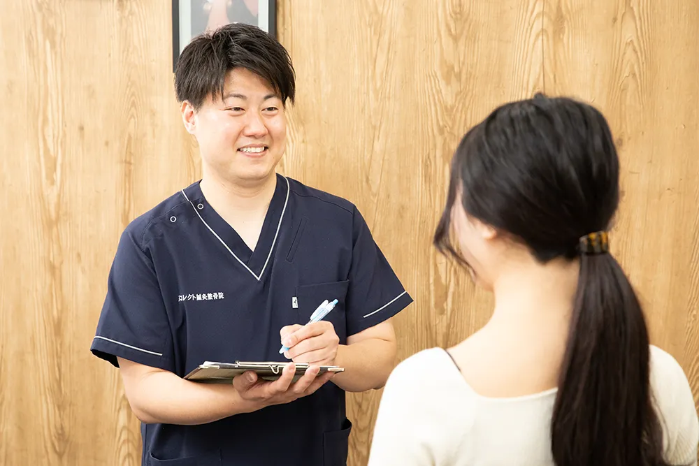 患者にヒアリングをする整体師