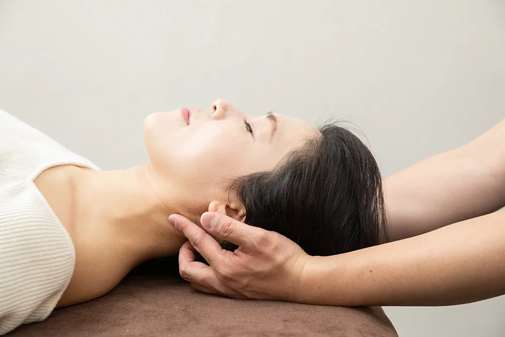 首に整体施術をする整体師