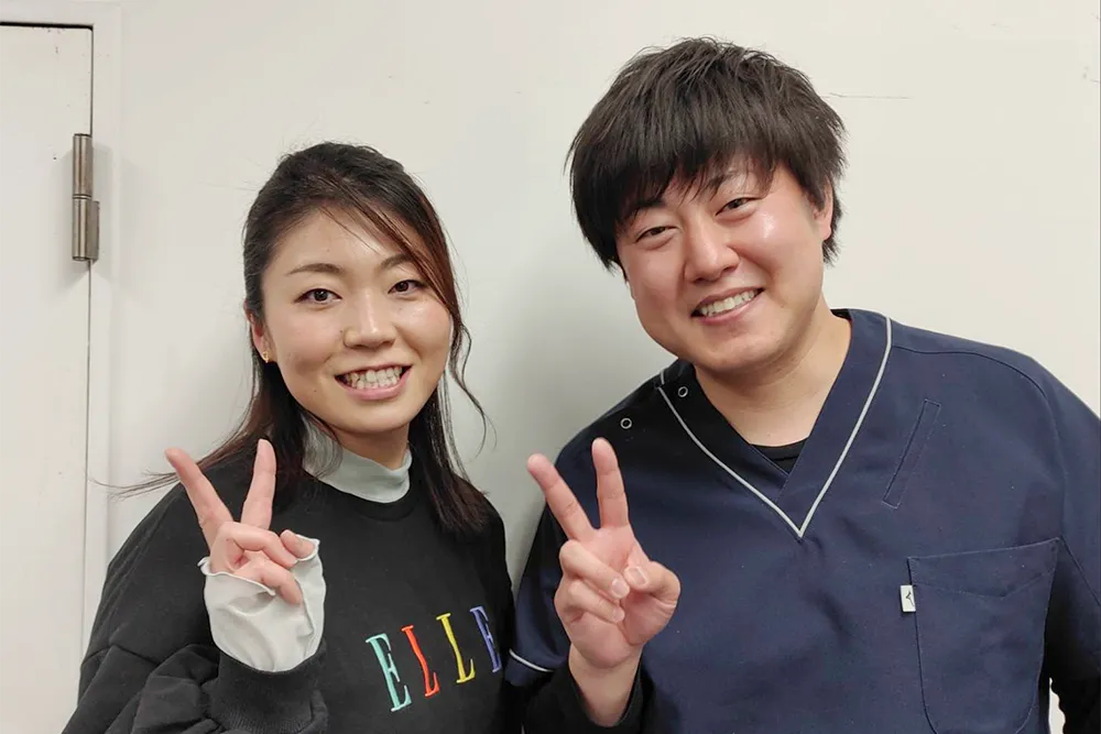 症状が改善した患者と並ぶ整体師
