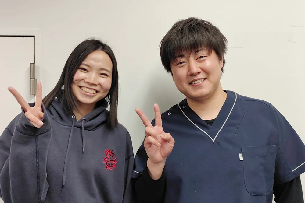 症状が改善した患者と並ぶ整体師