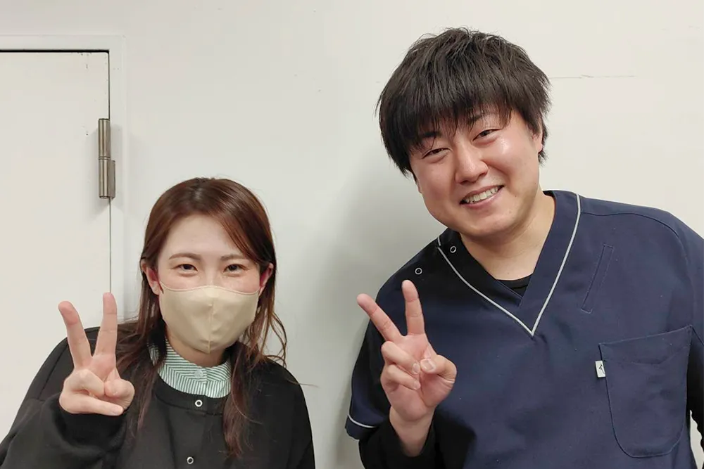 症状が改善した患者と並ぶ整体師