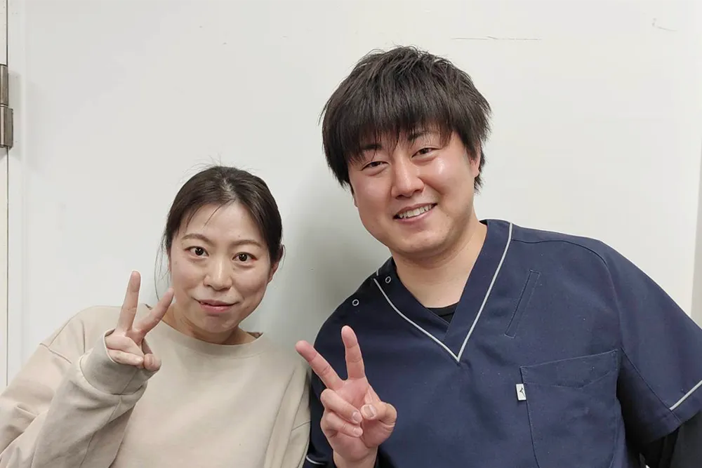 症状が改善した患者と並ぶ整体師